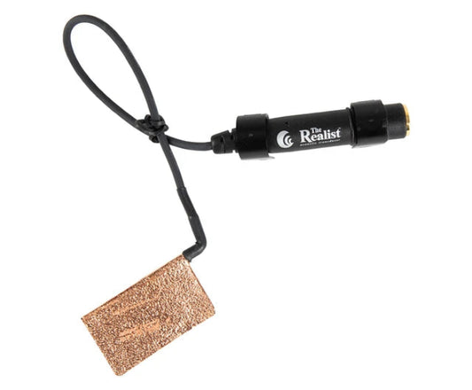 A black cylindrical electronic device with a black looped cable and a rectangular copper-colored textured tag, shown on a plain white background. The device features the brand logo 'The Realist' with 'The Realist Photography' printed on it.